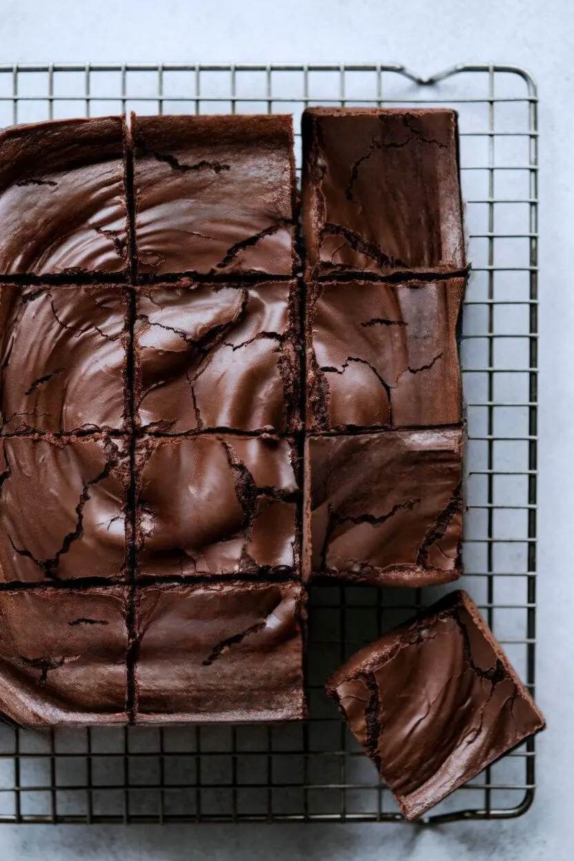 top-down view of fresh sourdough brownies cut into squares arranged on a cooling rack