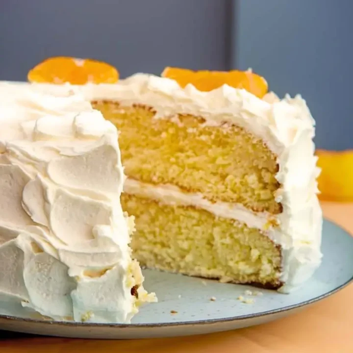 Mandarin orange cake with a slice removed, showcasing the two moist layers within.