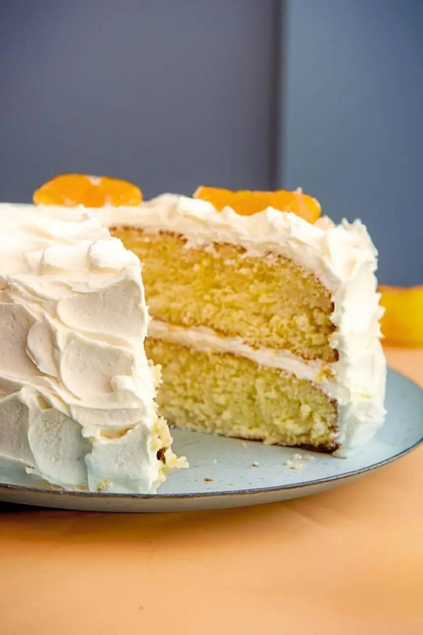 Mandarin orange cake with a slice removed, showcasing the two moist layers within.